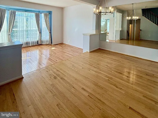 a view of a room with wooden floor and a window