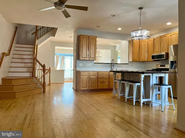 a kitchen with kitchen island a chandelier and wooden floors