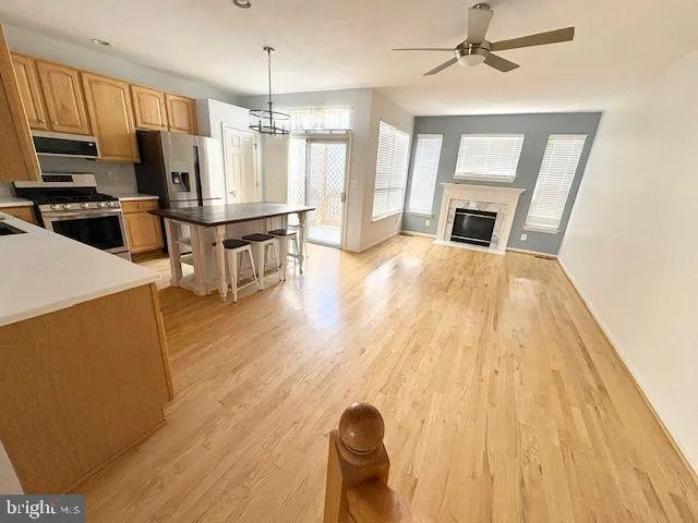 a open kitchen with kitchen island a refrigerator stove microwave and sink