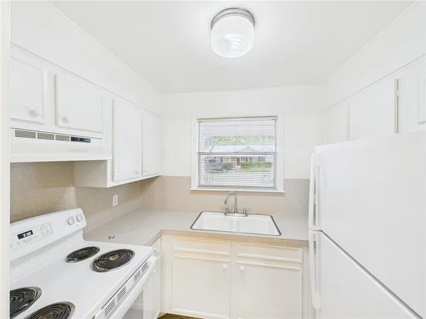 a view of kitchen cabinets and refrigerator