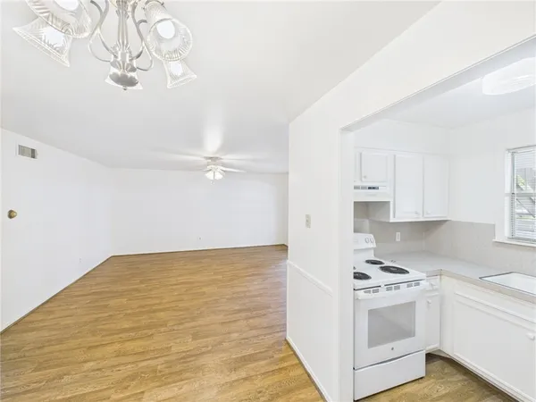 a view of kitchen with stove top oven and cabinets