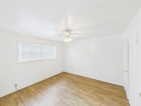 a view of a room with a ceiling fan and wooden floor