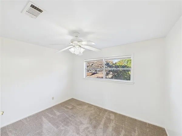 an empty room with a chandelier fan