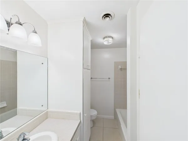 a bathroom with a granite countertop bathtub shower and toilet
