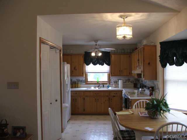 17270 Loving Union Road Disputanta, VA 23842 - Photo 4 of 7 a kitchen with cabinets a sink stainless steel appliances and dining table