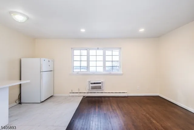 an empty room with a hardwood floor and window