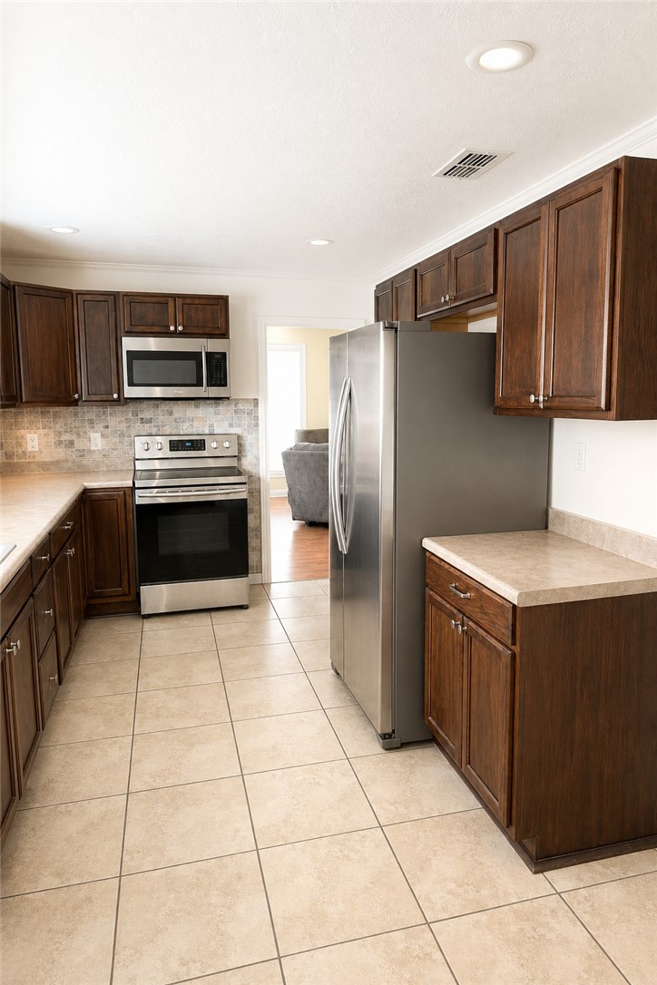 421 South Commerce Street Centerville, TX 75833 - Photo 9 of 23 a kitchen with stainless steel appliances granite countertop a refrigerator and a stove top oven