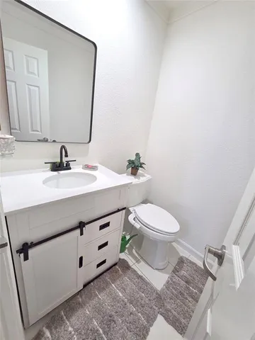 a bathroom with a sink vanity mirror and toilet