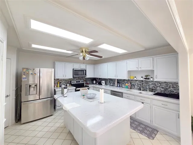 a kitchen with white cabinets and stainless steel appliances