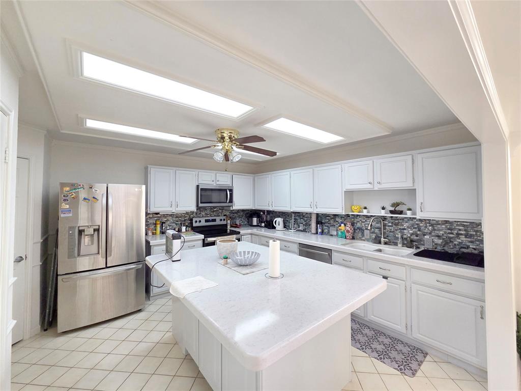 3908 Denham Way Plano, TX 75023 - Photo 15 of 23 a kitchen with white cabinets and stainless steel appliances