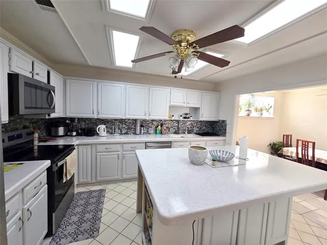 a kitchen with a center island a counter space cabinets and stainless steel appliances
