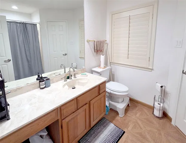 a bathroom with a double vanity sink toilet and a mirror