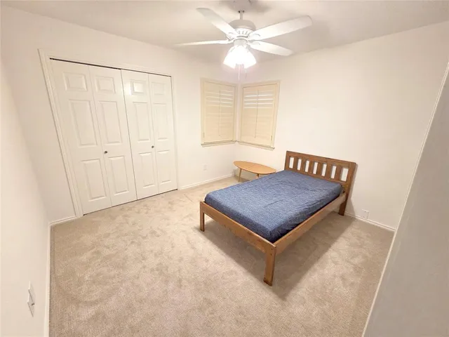 a view of a room with a ceiling fan and wooden floor