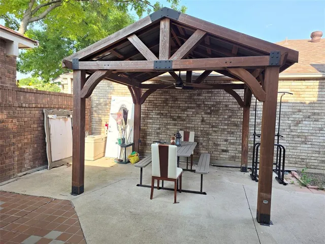 a patio with table and chairs and potted plants