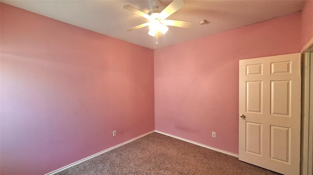 953 Hannah Way Dallas, TX 75253 - Photo 11 of 22 Interior room featuring textured walls, a white multi-panel door, and a ceiling fan with integrated lighting
