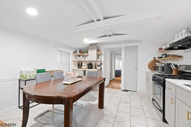 a open kitchen with stainless steel appliances kitchen island granite countertop a table and chairs in it