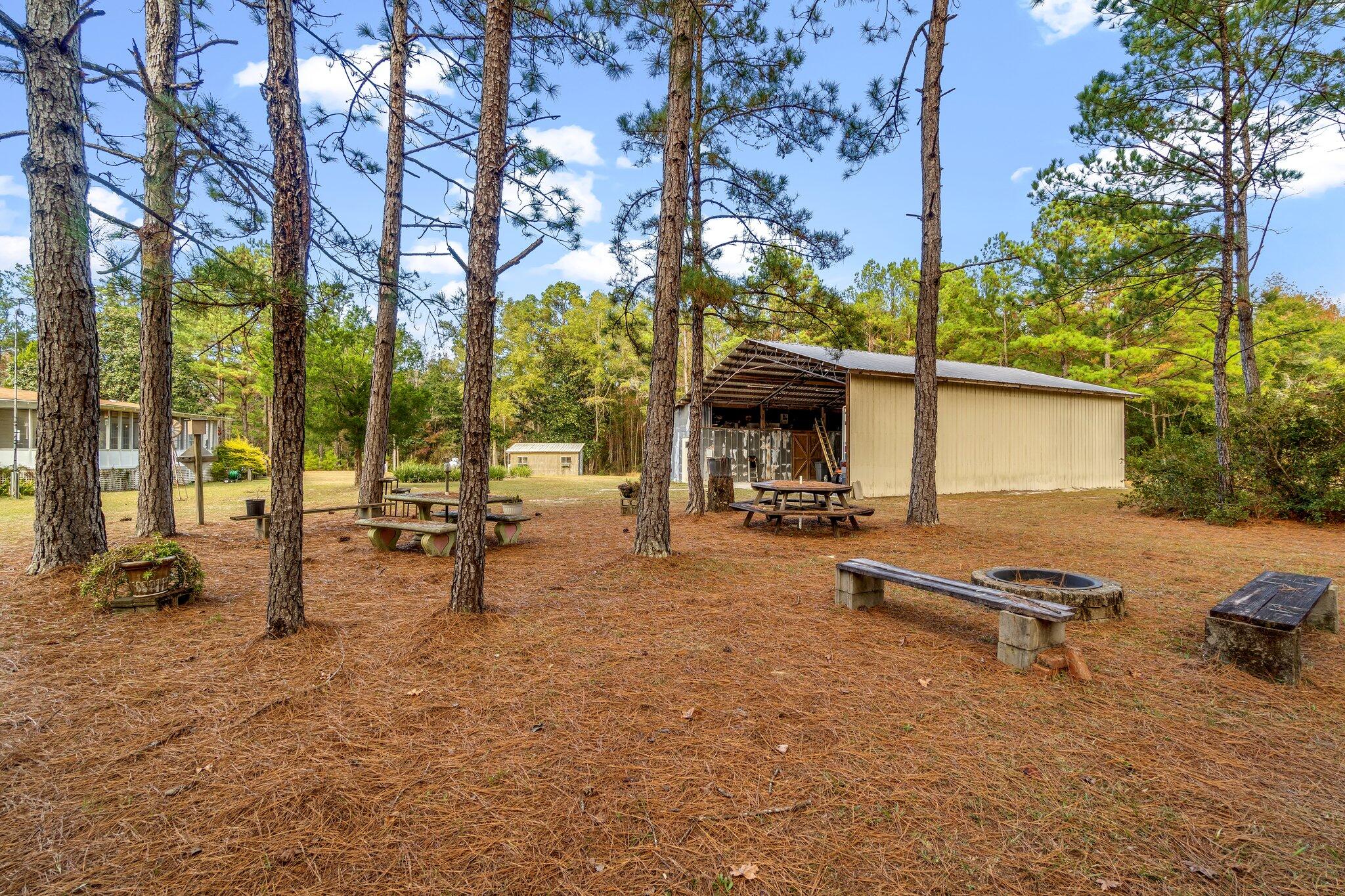 4281 Shell Landing Road Vernon, FL 32462 - Photo 35 of 55 a view of a swimming pool with chairs in front of house