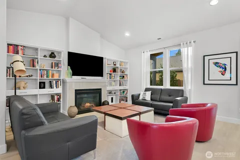 a living room with furniture a kitchen and a fireplace