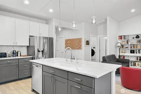 a kitchen with stainless steel appliances granite countertop a sink a stove top oven a counter space and cabinets