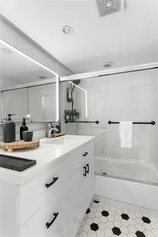 a bathroom with a tub sink and mirror