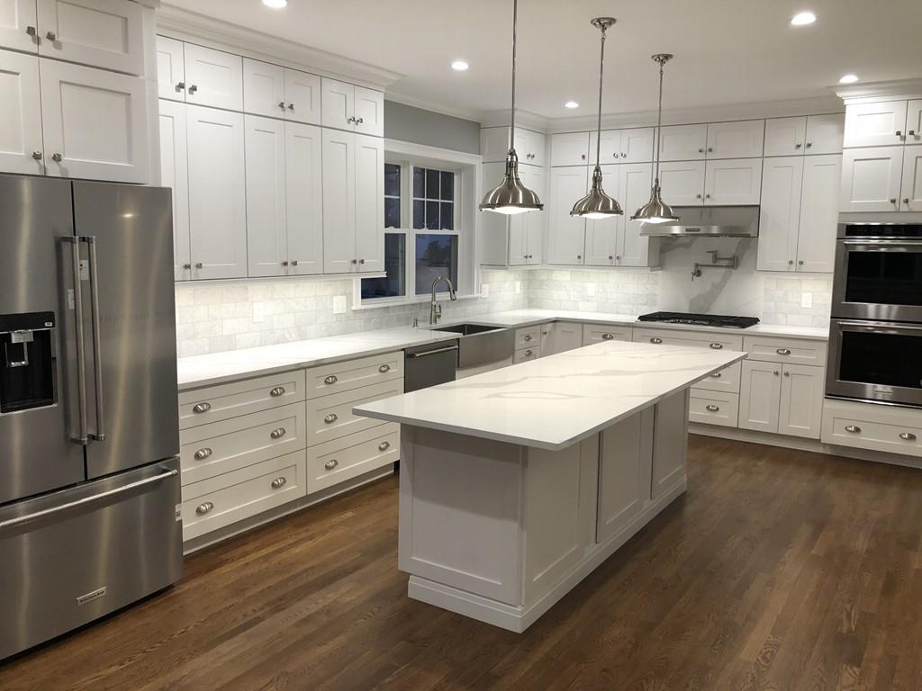 196 Reedsdale Road Milton, MA 02186 - Photo 4 of 20 a kitchen with kitchen island granite countertop a stove a sink a refrigerator and white cabinets with wooden floor