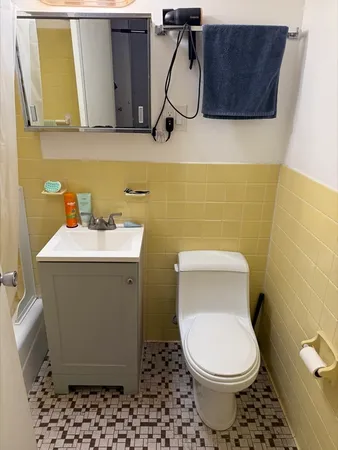 a bathroom with a toilet and a mirror