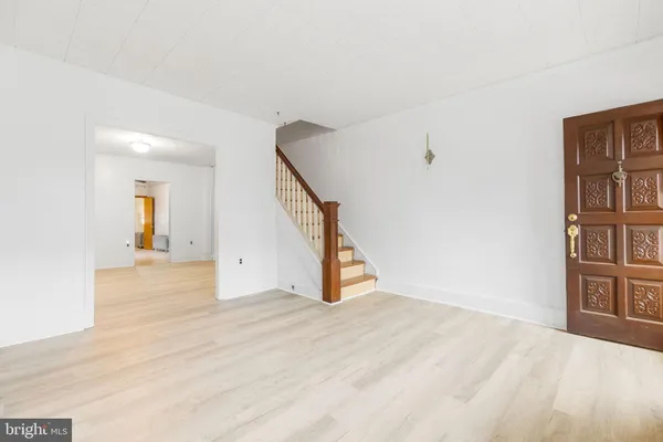 a view of an empty room with wooden floor and entryway
