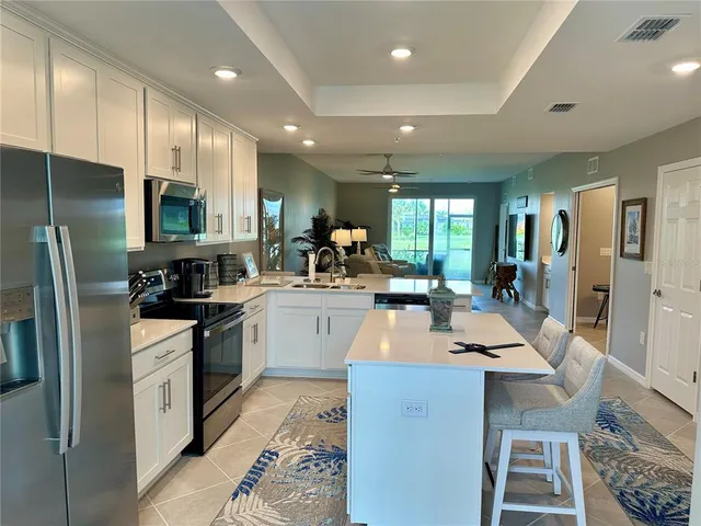 a kitchen with kitchen island granite countertop a sink a stove a counter top space and appliances