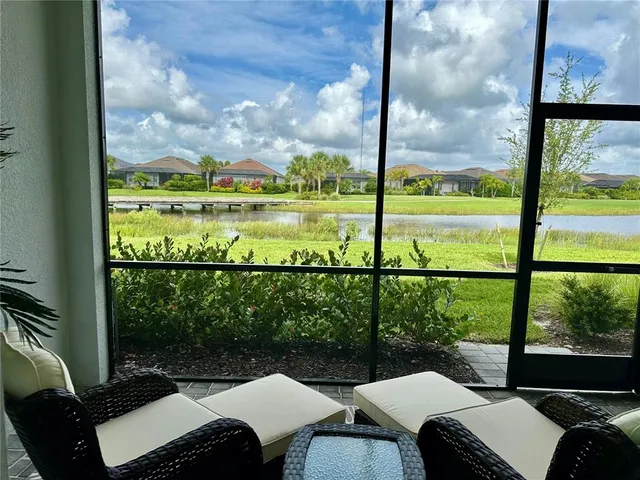 a view of a swimming pool with a lawn chairs and plants
