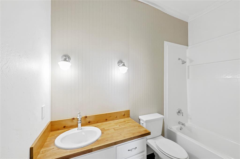 396 Ranchview Court Bowie, TX 76230 - Photo 35 of 38 a bathroom with a granite countertop sink and a mirror