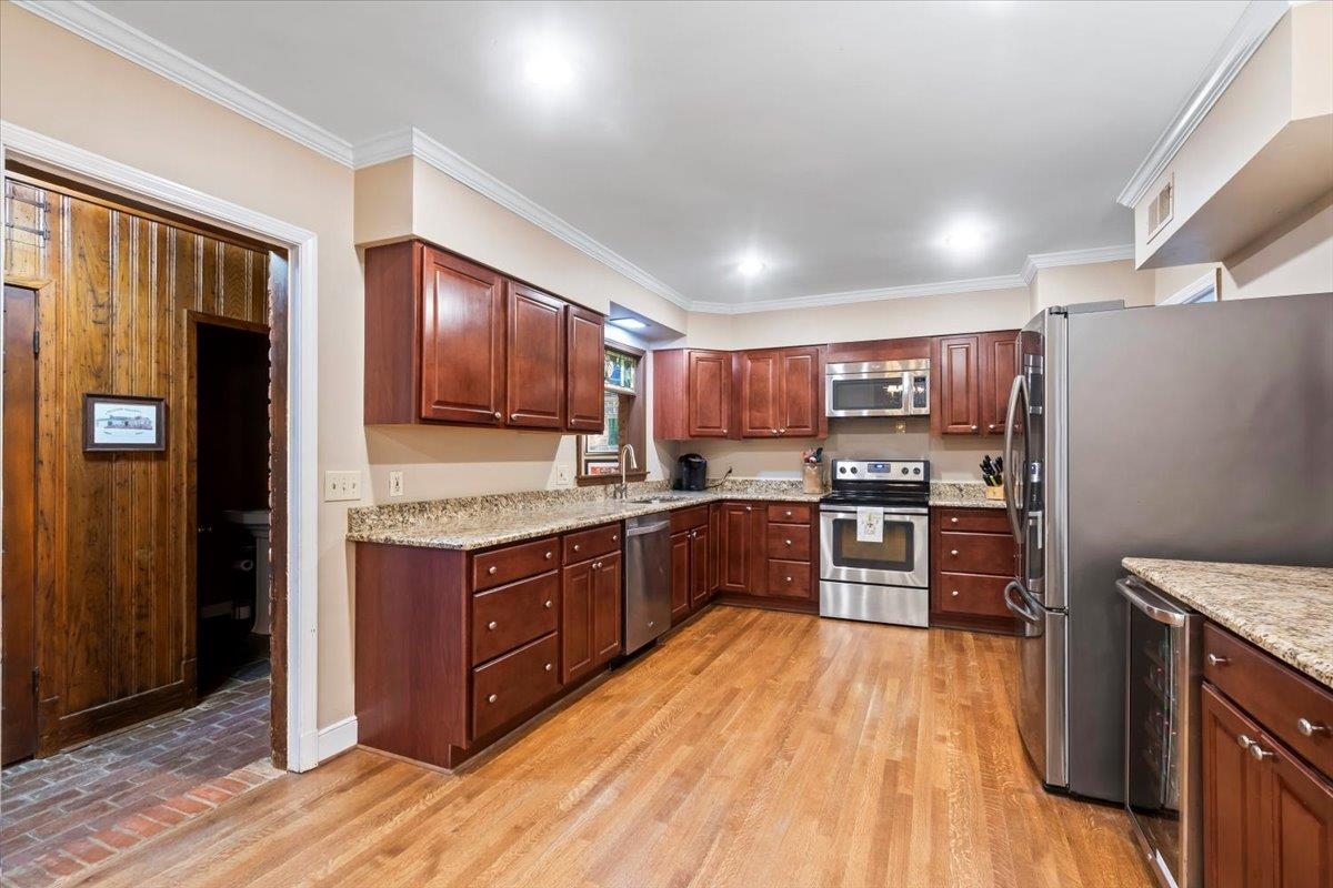 4277 Sequoia Road Memphis, TN 38117 - Photo 13 of 36 a room with stainless steel appliances kitchen island granite countertop wooden floors and a view of living room