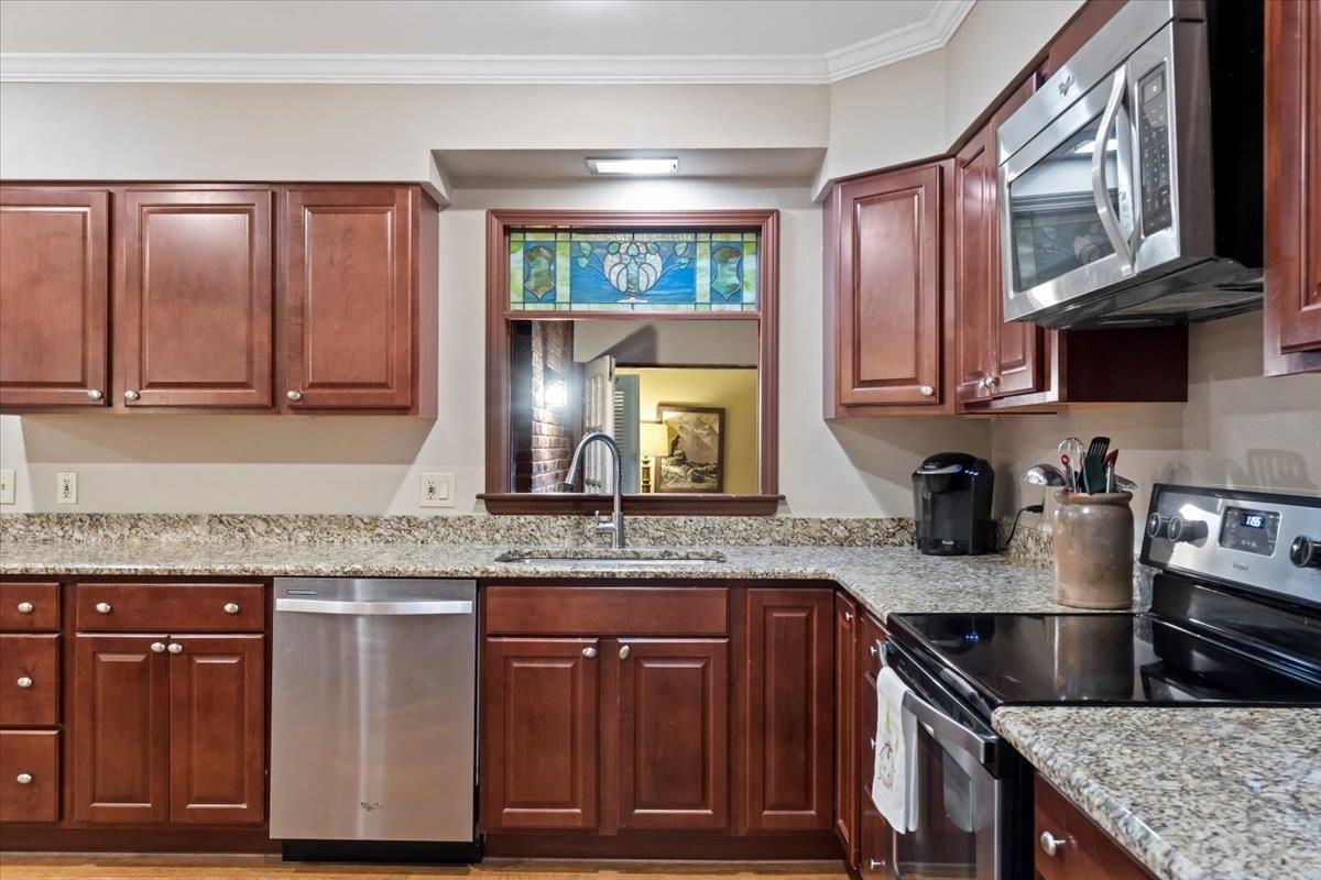 4277 Sequoia Road Memphis, TN 38117 - Photo 14 of 36 a kitchen with granite countertop a sink stove and cabinets
