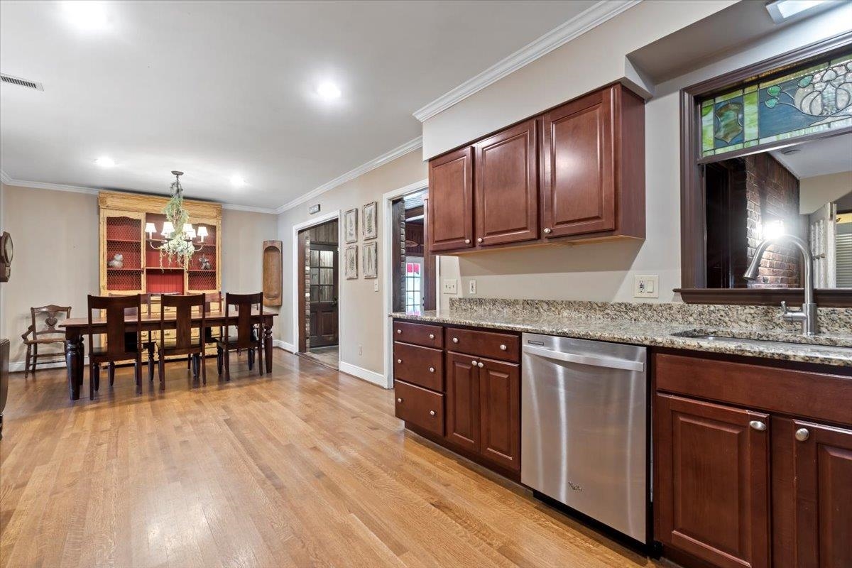 4277 Sequoia Road Memphis, TN 38117 - Photo 15 of 36 a kitchen with stainless steel appliances granite countertop wooden floors and wooden cabinets