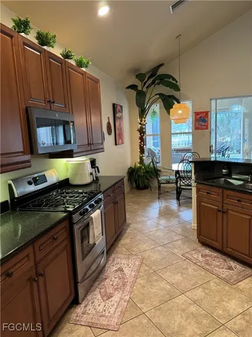 a kitchen with stainless steel appliances granite countertop a stove a sink and a microwave