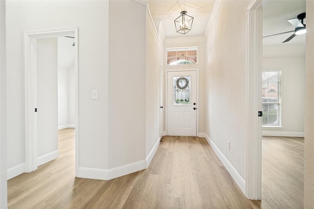 3020 Ridge Hollow Drive Plano, TX 75023 - Photo 2 of 28 Entryway featuring wood-finish flooring, white trim, and a frosted glass front door with an arched transom window