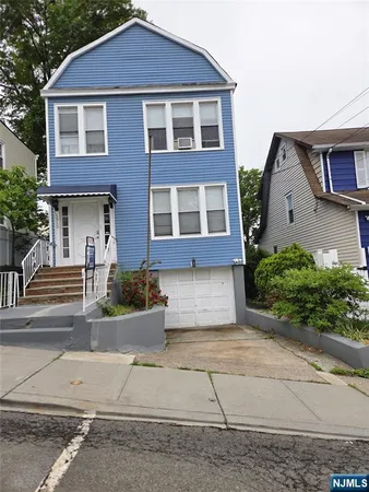a front view of a house with a yard and potted plants