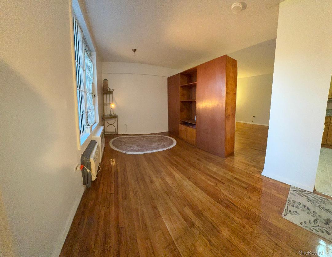 41-31 51st Street, Unit 6M Queens, NY 11377 - Photo 11 of 23 Unfurnished living room featuring dark wood finished floors and baseboards
