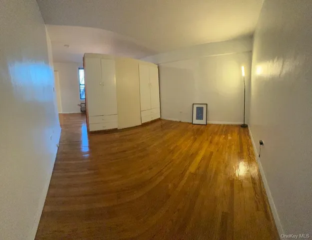 a view of a big room with wooden floor and brick walls