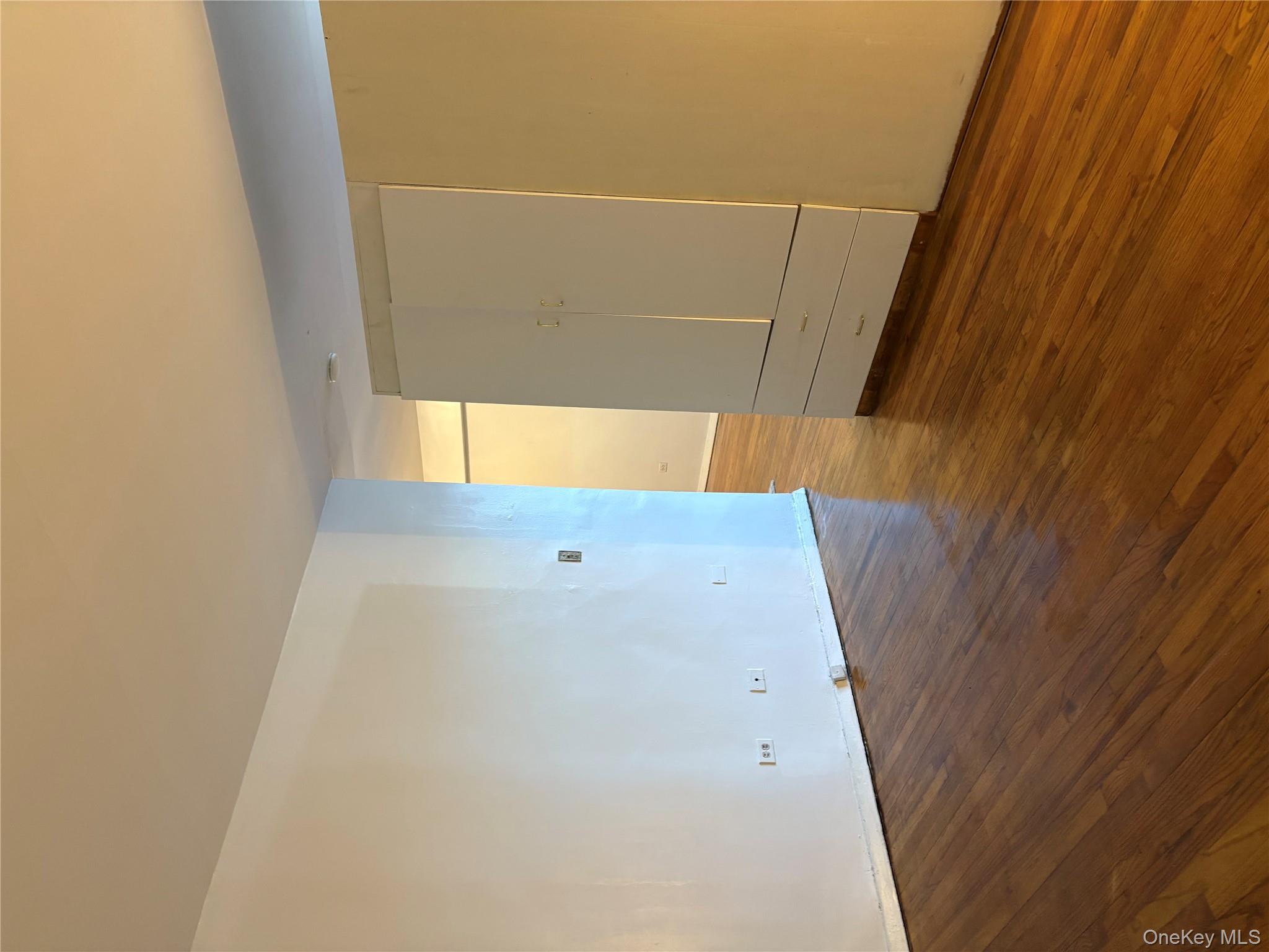 41-31 51st Street, Unit 6M Queens, NY 11377 - Photo 13 of 23 Empty room with baseboards and dark wood finished floors