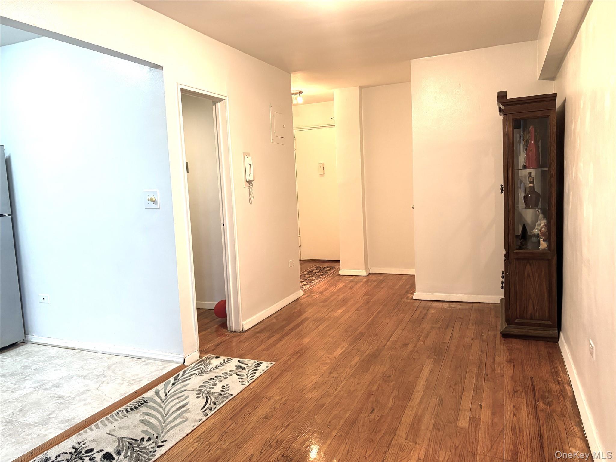 41-31 51st Street, Unit 6M Queens, NY 11377 - Photo 3 of 23 Spare room featuring baseboards and wood finished floors