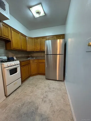 a kitchen with stainless steel appliances granite countertop a refrigerator a stove a sink and a microwave