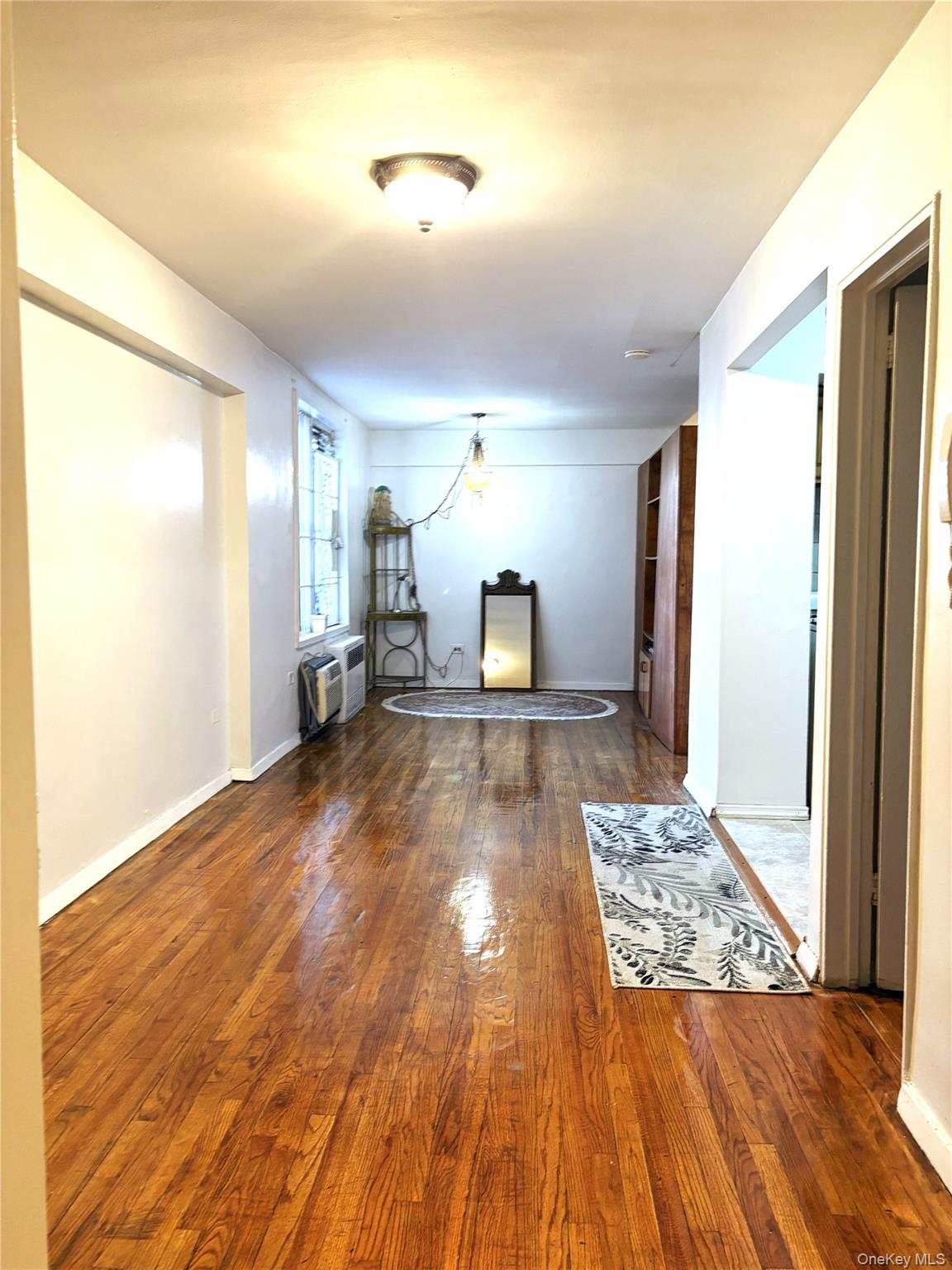 41-31 51st Street, Unit 6M Queens, NY 11377 - Photo 9 of 23 Corridor with wood finished floors, an AC wall unit, and baseboards