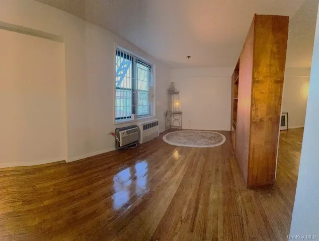 a view of a room with wooden floor and bench