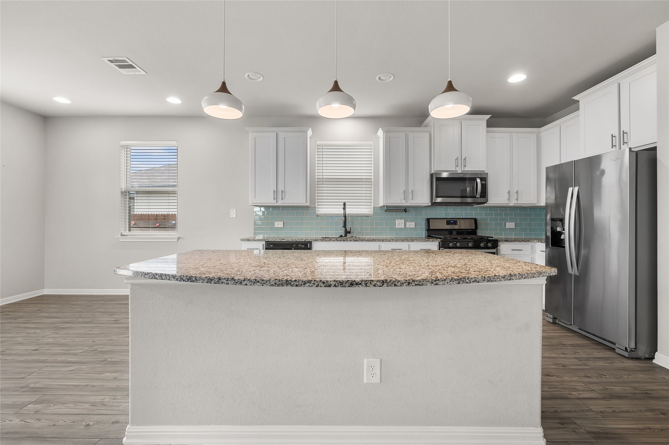 101 Lambert Street Leander, TX 78641 - Photo 12 of 33 A well-appointed kitchen features a large island and ample cabinetry, ready for culinary endeavors.