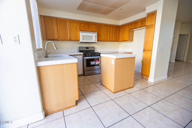 a kitchen with a sink a stove top oven a counter top space and cabinets