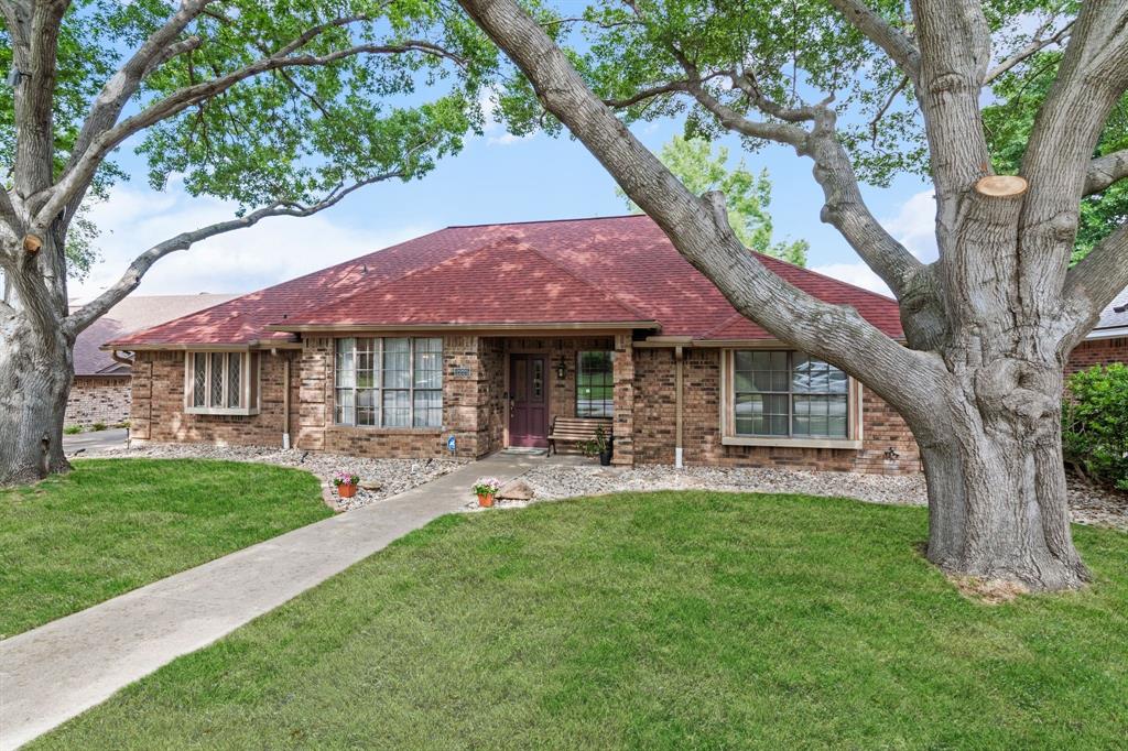 Ranch-style home featuring brick siding, a shingled roof, and a front yard