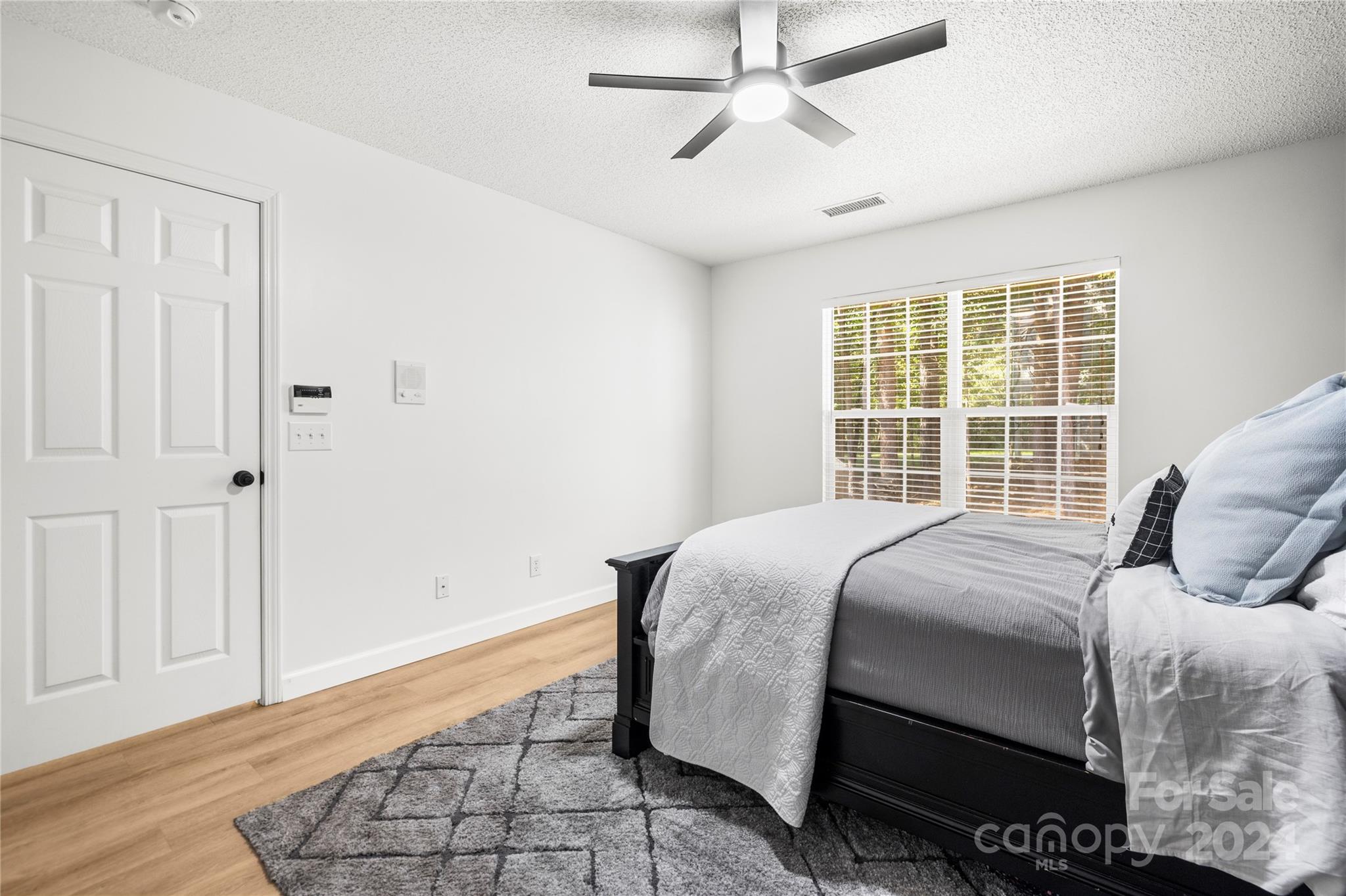 4909 Deerton Road Charlotte, NC 28269 - Photo 12 of 31 a bedroom with a bed and wooden floor