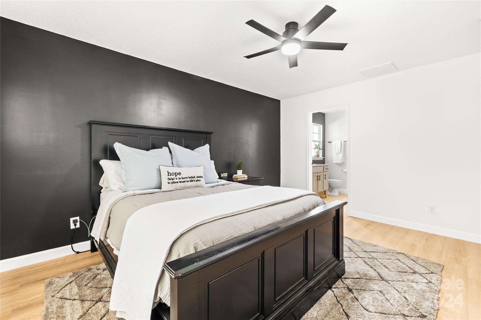 4909 Deerton Road Charlotte, NC 28269 - Photo 13 of 31 a spacious bedroom with a bed and a chandelier