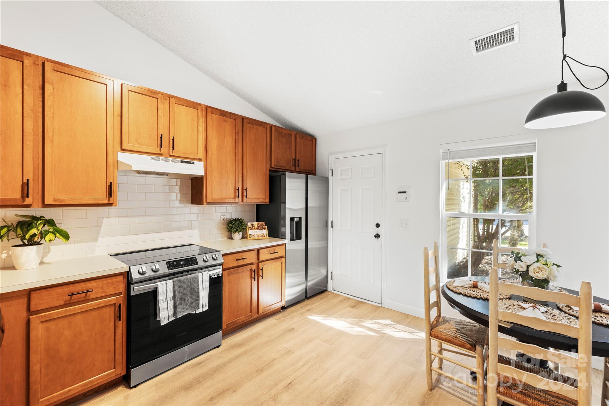 4909 Deerton Road Charlotte, NC 28269 - Photo 3 of 31 a kitchen with stainless steel appliances granite countertop a stove a sink dishwasher and a refrigerator with wooden floor