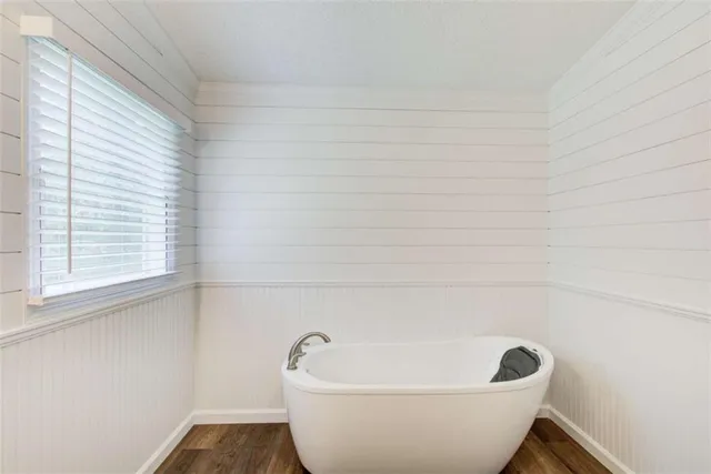 a white bath tub sitting in a bathroom next to a window